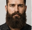 Porträt eines Mannes mit dichtem, langem Vollbart und kurzem Haarschnitt. Maskuliner Look mit markanten Gesichtszügen.
